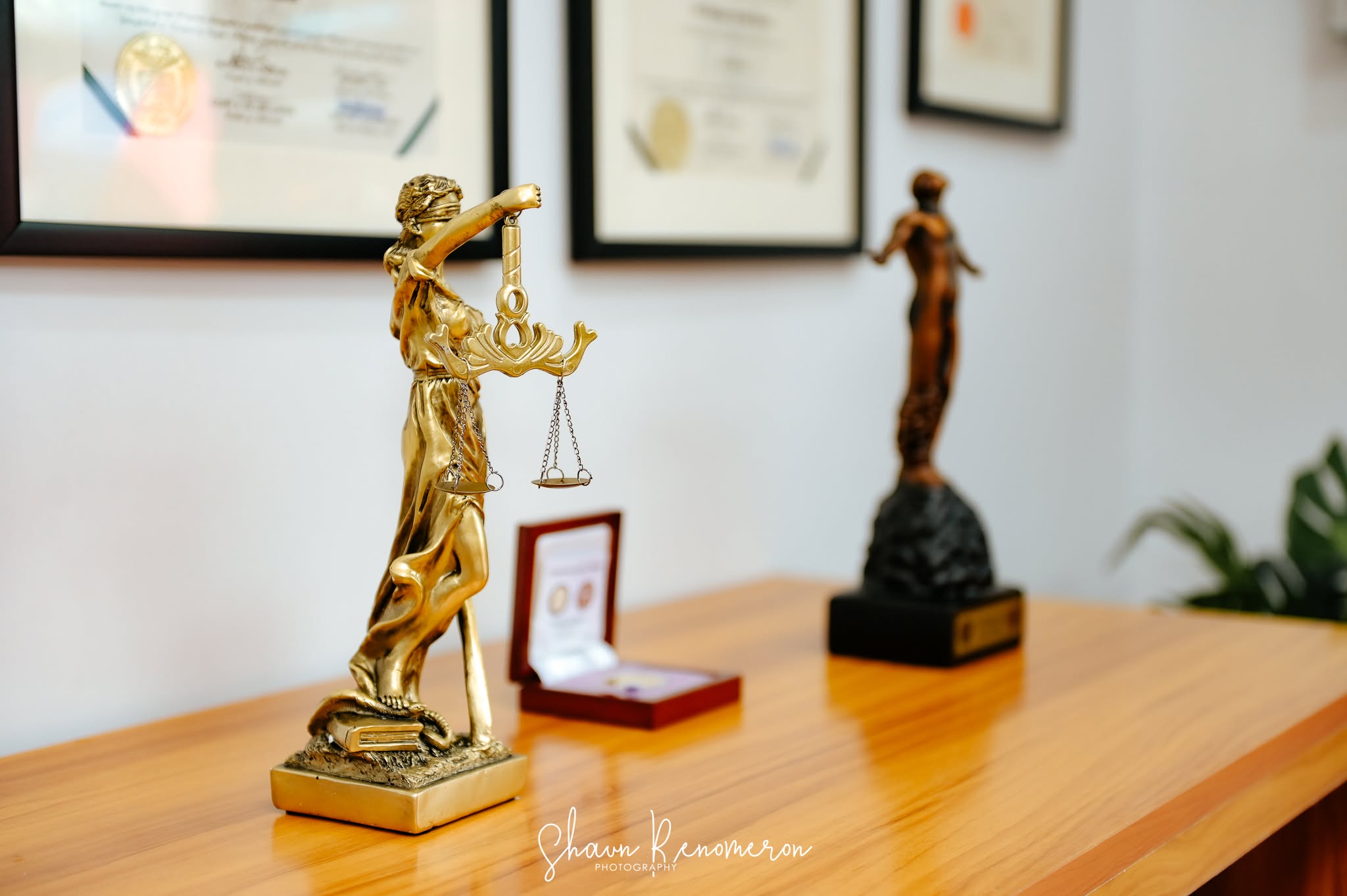 Lady Justice statue and legal credentials inside the AAA Law office